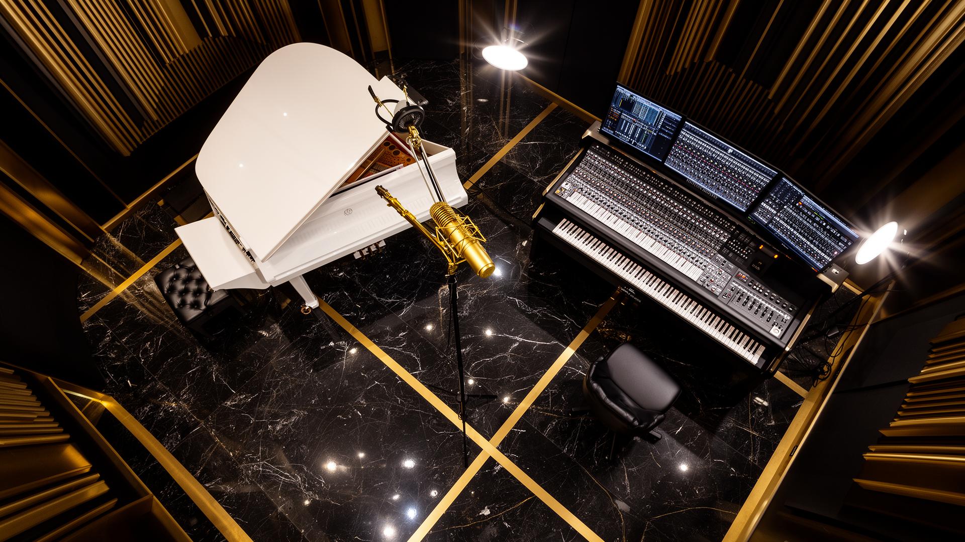 Overhead view of white grand piano and gold microphone on marble floor